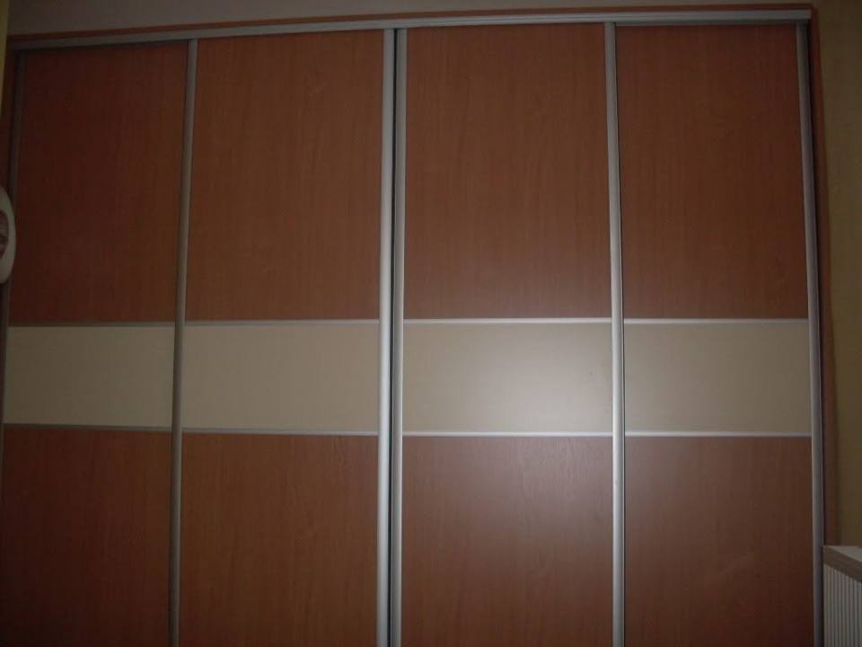 Kleiderkasten in Nussbaum-Dekor mit vier Türen und cremefarbenem Glasband.
