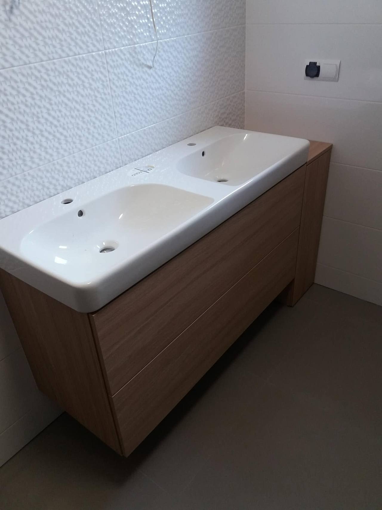 Hängender Nussbaumschrank unter dem Doppelbecken an der Wand