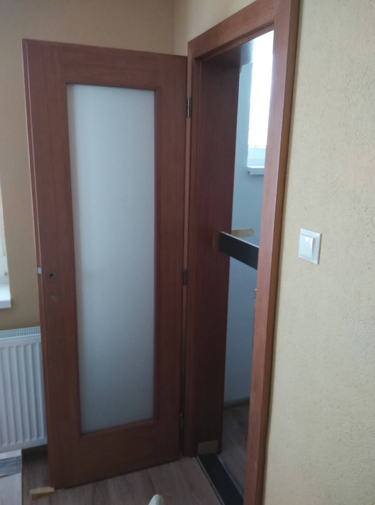 Leicht geöffnete Nussbaum-Tür mit Blick auf die Stiege