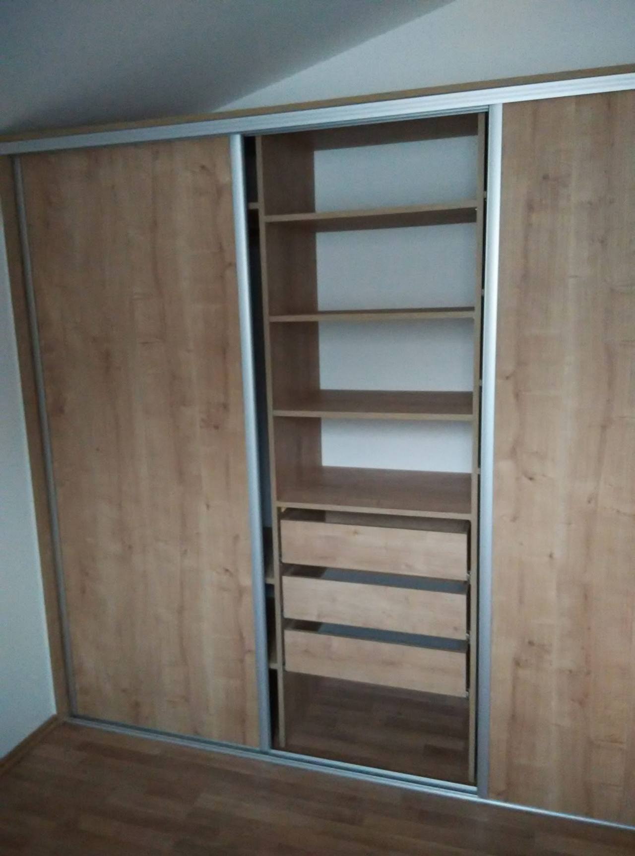 Geöffneter Schiebetürkasten in Eichendekor mit Fachböden und weißen Laden.