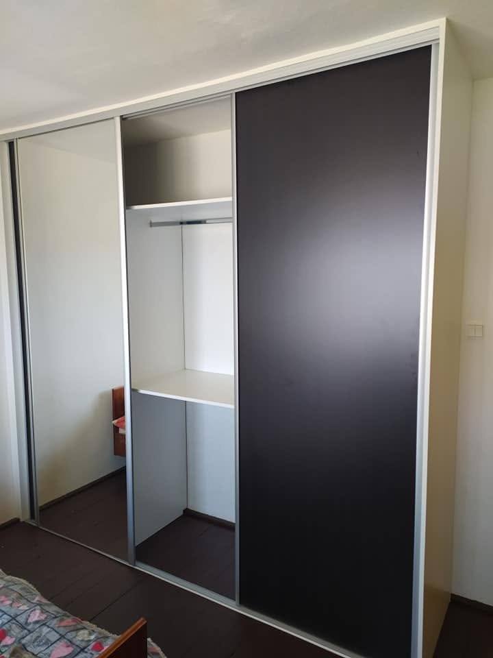 Skriňa s čiernou dverou a bielym vnútrom s tyčou