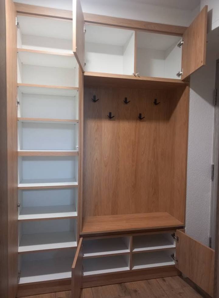 Offener Kasten mit Leiterfächern, Drahtkörben und Kleiderstange.