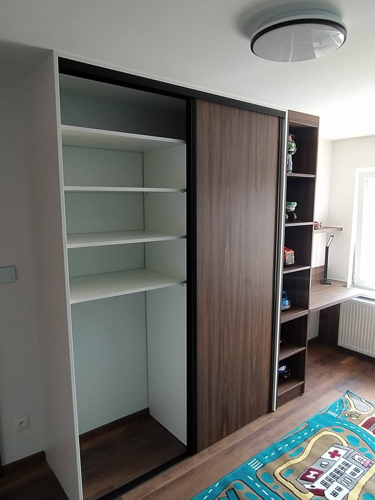 Geöffneter Kasten in Nussbaumdekor mit weißen Fachböden im Kinderzimmer