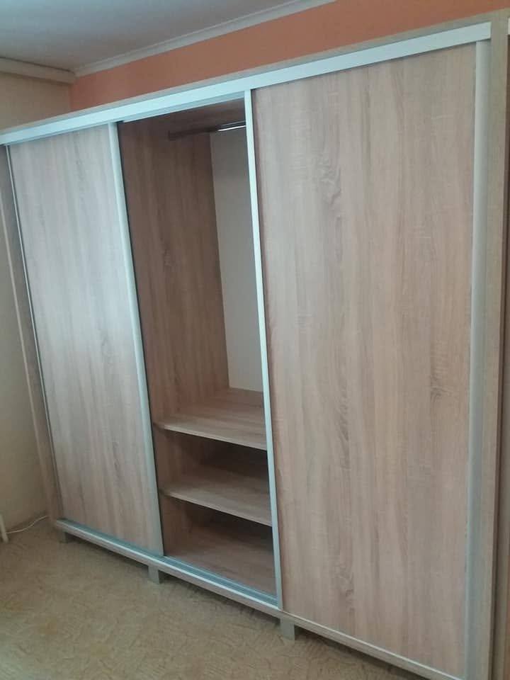 Inneres des Kastens mit Kleiderstange und offenen Böden.