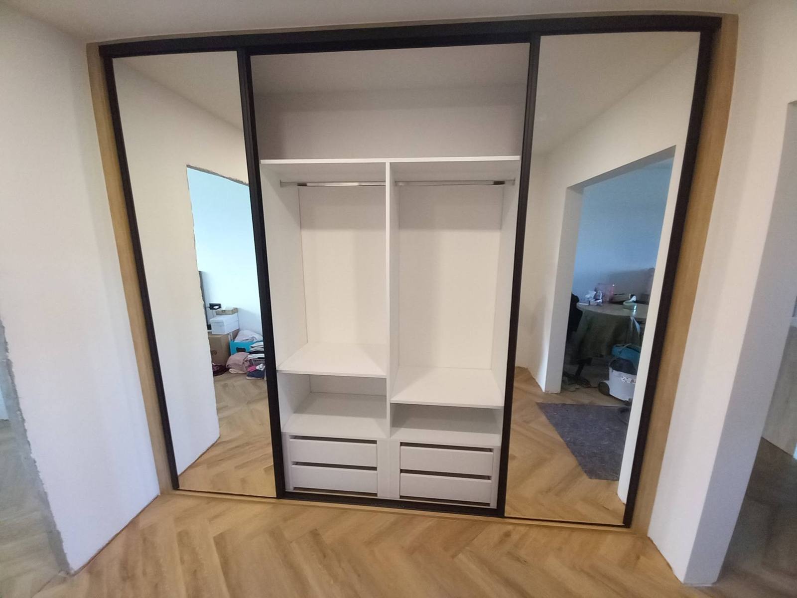 Geöffneter Spiegel-Schiebetürkasten mit weißem Innenausbau und Laden.