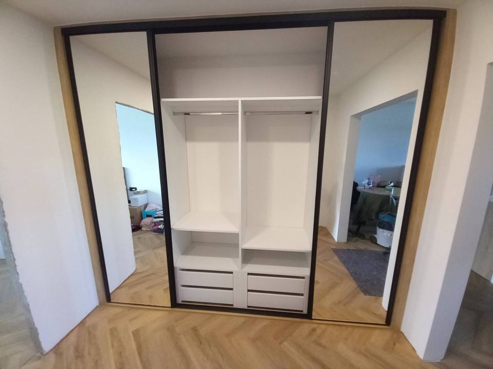 Geöffneter Spiegel-Schiebetürkasten mit weißem Innenausbau und Laden.