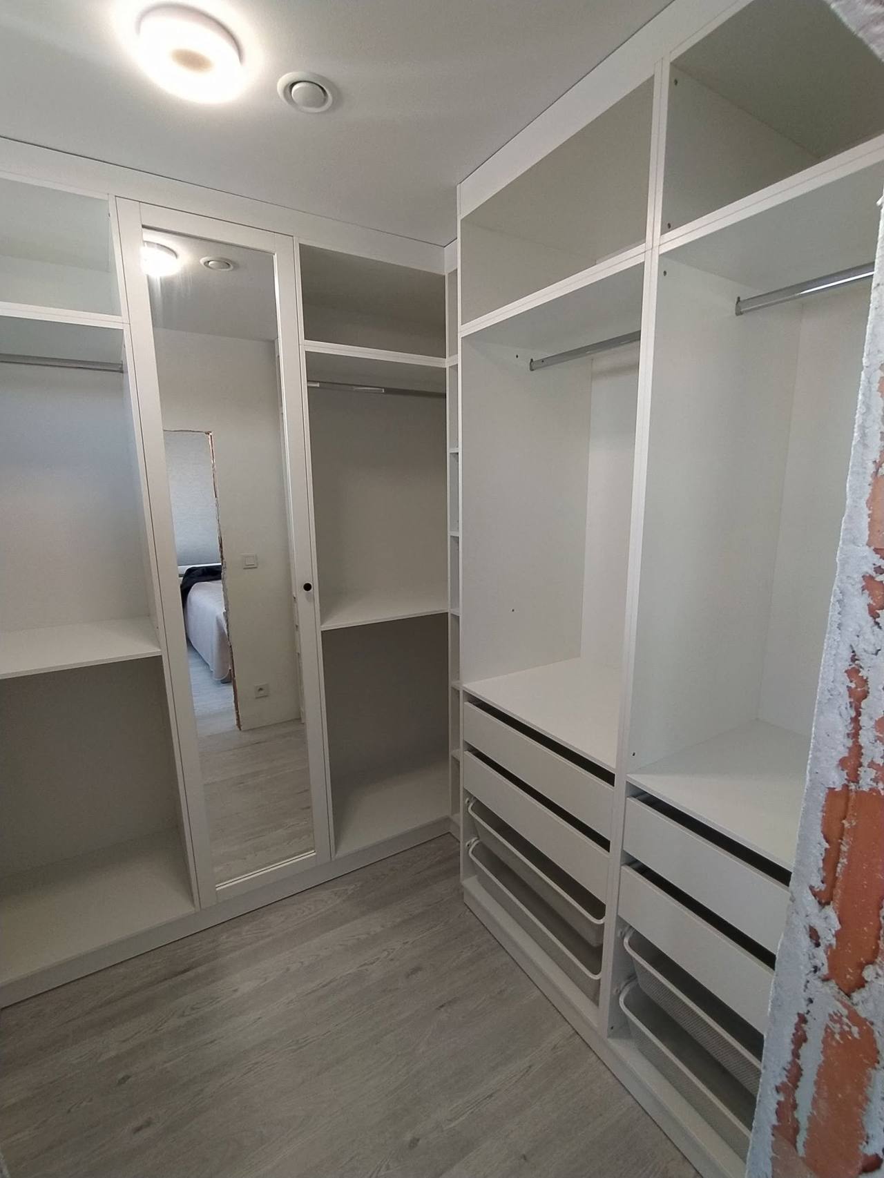 Ankleidezimmer mit weißen Borden und Laden an der Wand
