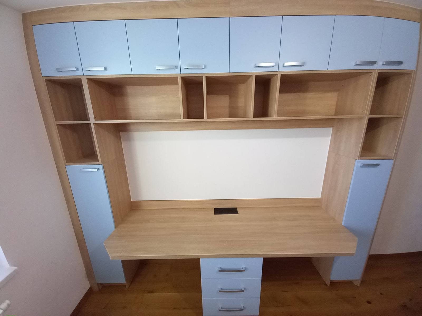 Schreibtisch mit hängendem Fächerregal und hellblauen Türen