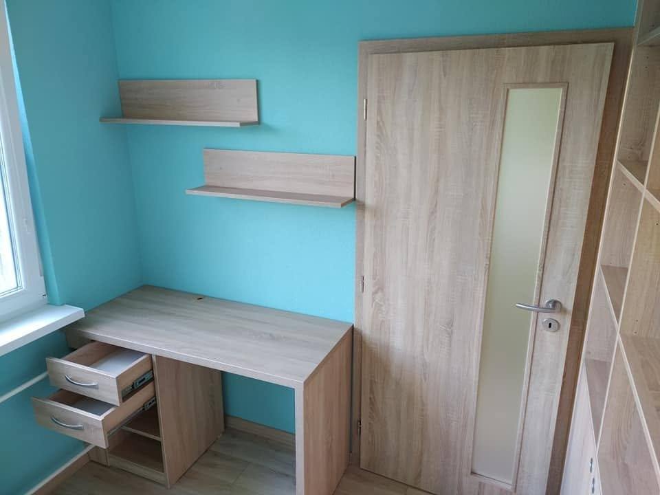 Schreibtisch in Eichendekor mit herausgezogenen Laden und Borden