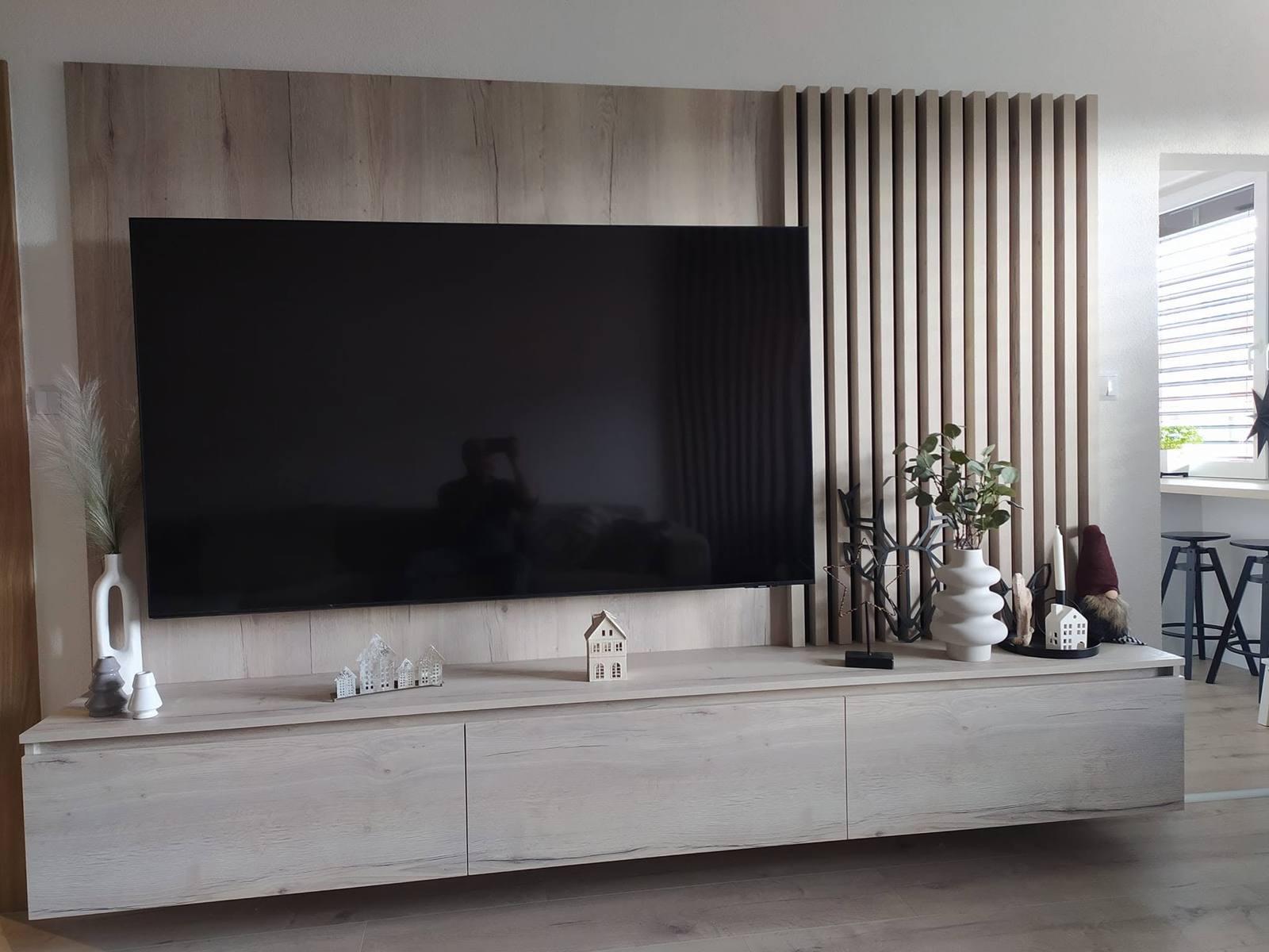 TV-Wand mit Eichenverkleidung, Lamellen und schwebendem grauem Möbel