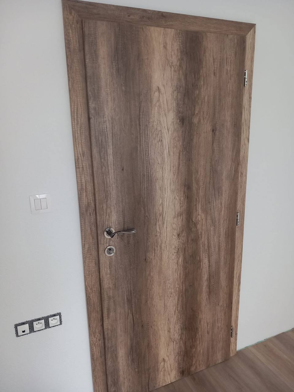 Volle Eichentür mit kräftiger Holzmaserung in der weißen Wand