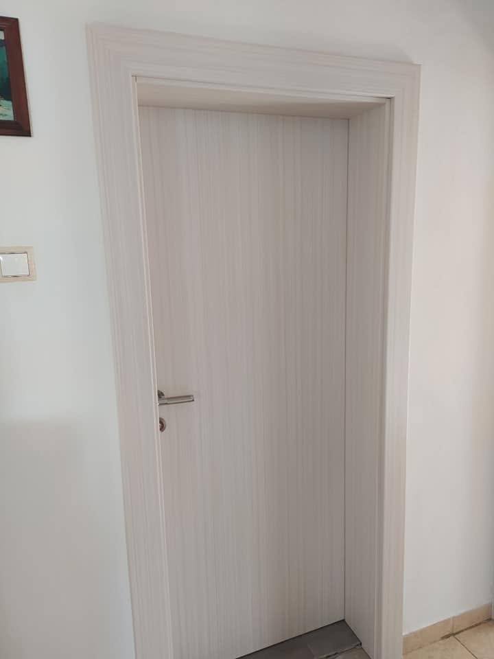 Helle massive Tür in gebleichtem Dekor mit Edelstahlgriff.