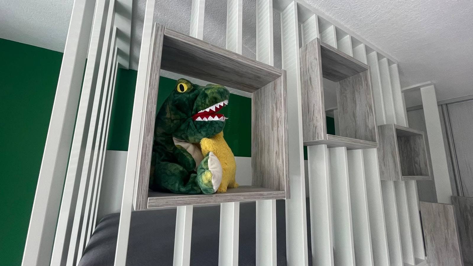 Biele lamely s policovou nikou a hračkou dinosaura v detskej izbe