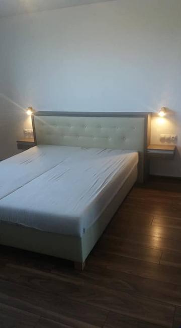 Doppelbett mit Polsterkopfteil im Schlafzimmer mit dunklem Boden