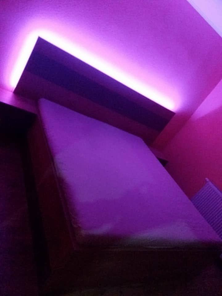 Dasselbe Bett mit violetter LED-Beleuchtung über dem Kopfteil