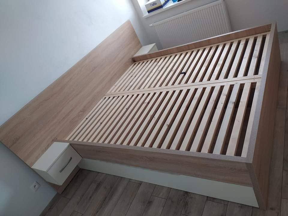 Manželská posteľ v svetlom dekore s bielymi visiacimi stolíkmi