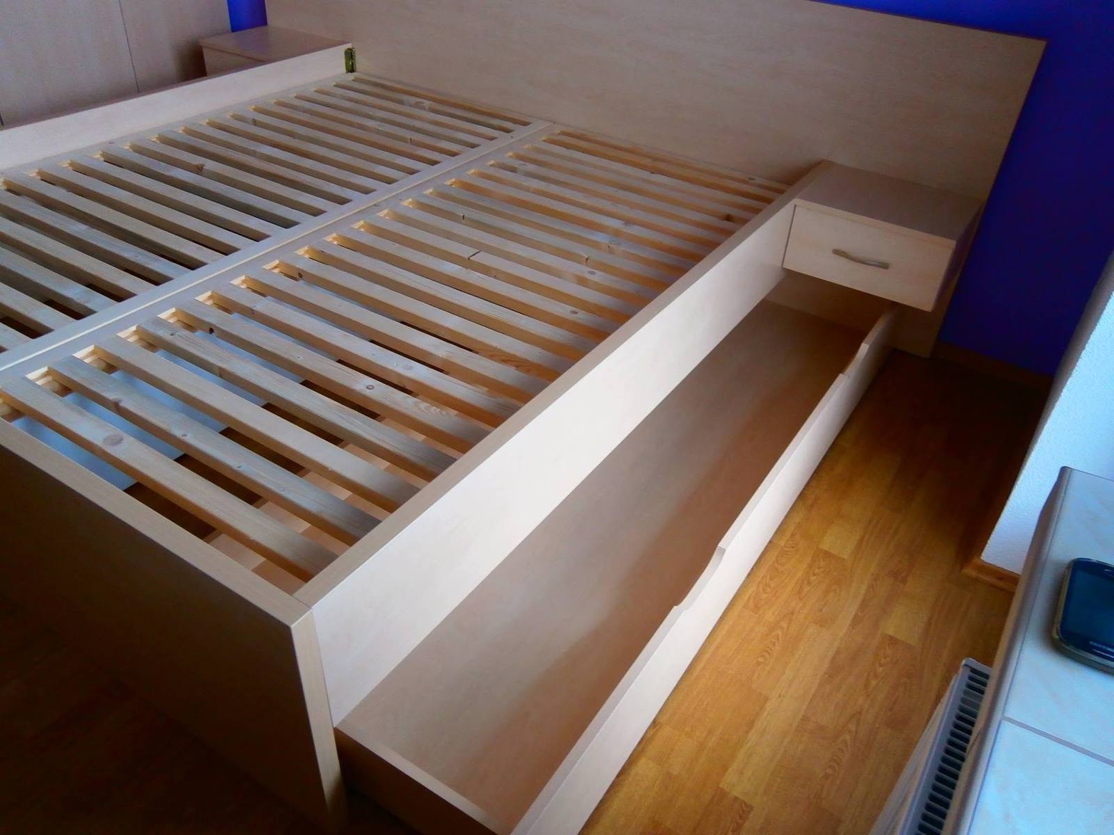 Herausgezogene lange Lade unter dem Bett mit zwei Lattenrosten