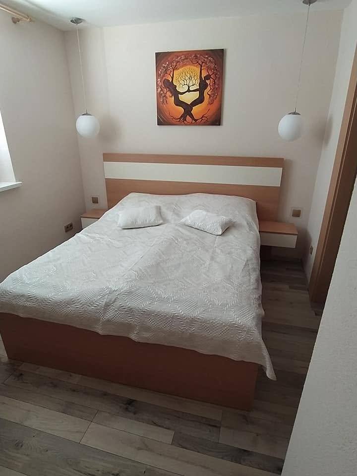 Spálňa s dvojfarebnou manželskou posteľou a visiacimi stolíkmi