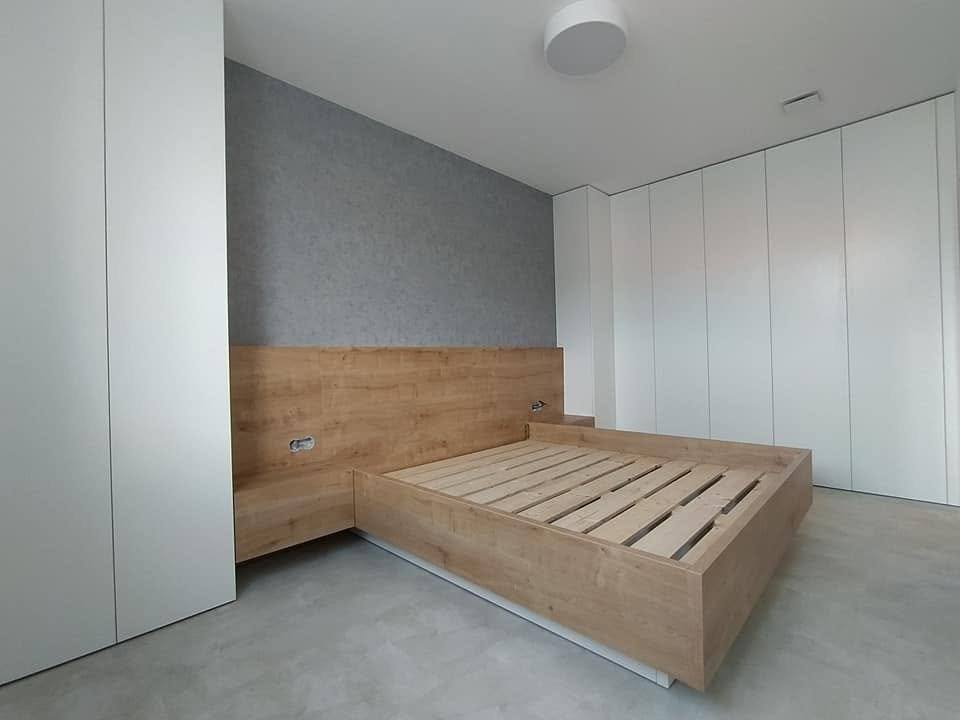 Bett mit Nachtkästchen auf zurückversetztem weißem Sockel