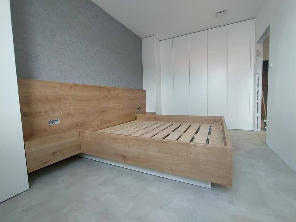 Schlafzimmer unter der Dachschräge mit Eichenbett und weißen Kästen