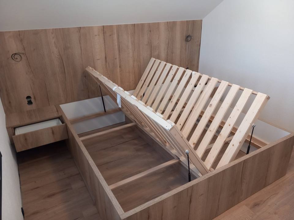 Bett mit zwei hochgeklappten Lattenrosten und Eichenpaneel dahinter