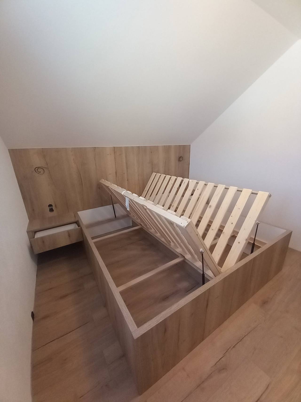 Bett mit hochklappbarem Lattenrost im Dachgeschoß unter der Schräge