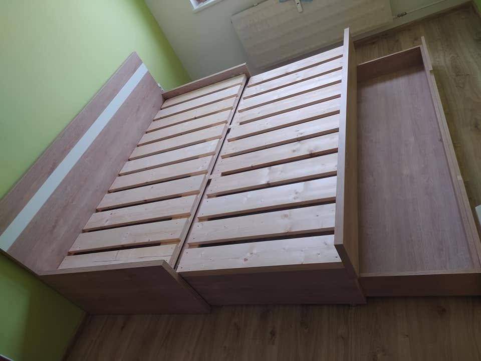 Dlhý úložný box vysunutý pozdĺž boku manželskej postele