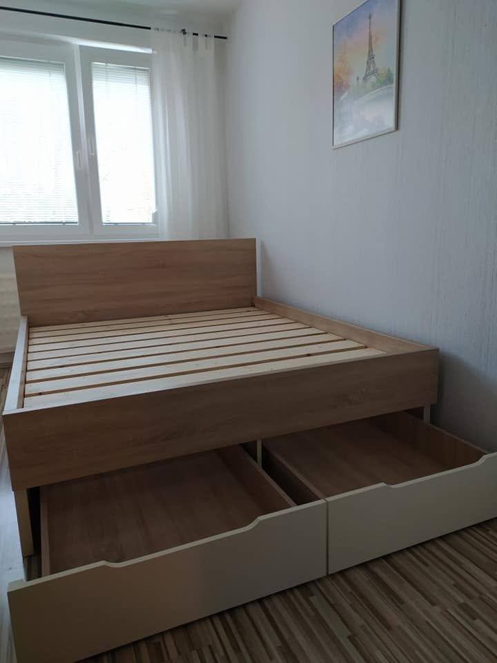 Herausgezogene Stauraumladen unter dem Doppelbett beim Fenster