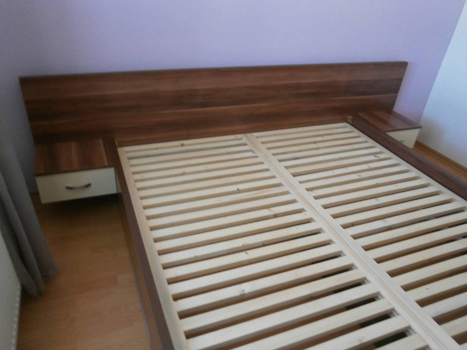 Posteľ s dlhým orechovým čelom a integrovanými nočnými stolíkmi