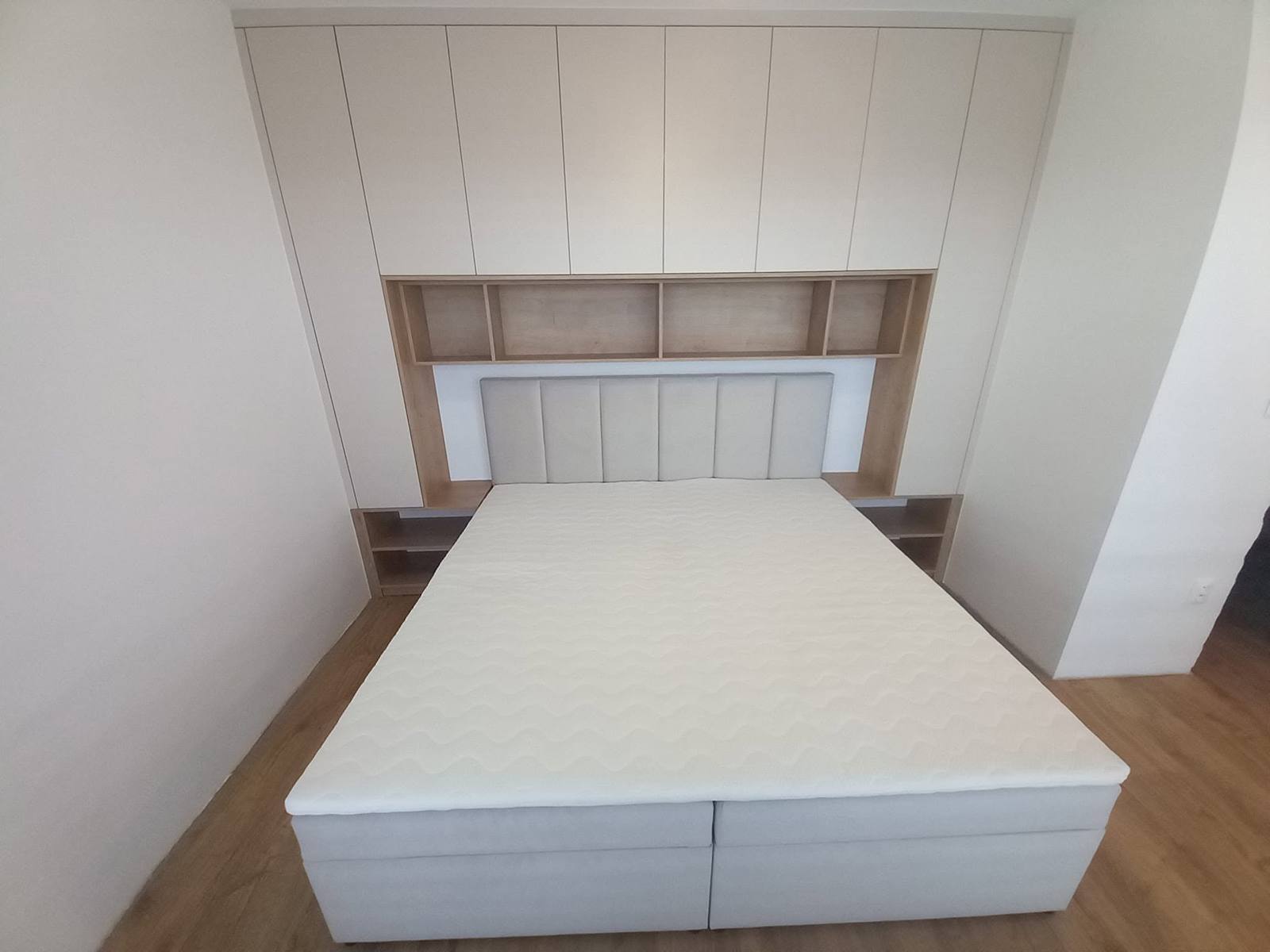 Schlafzimmerverbau mit Kästen bis zur Decke und Bett in der Nische