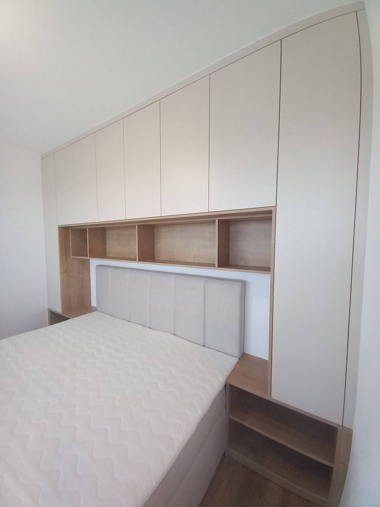 Kastenwand folgt der Dachschräge über dem Bett mit Polsterkopfteil