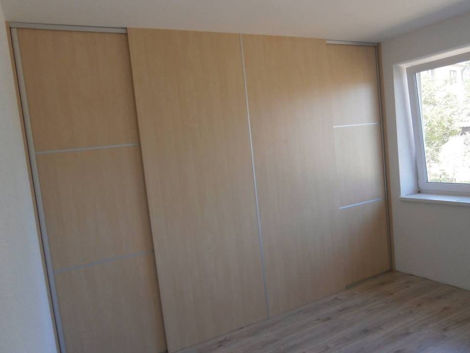 Heller Schiebetürenkasten über die ganze Wand neben dem Fenster