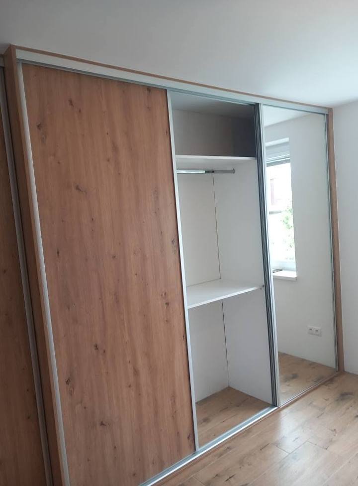 Verschobener Spiegelflügel, dahinter Kleiderstange mit Fachboden