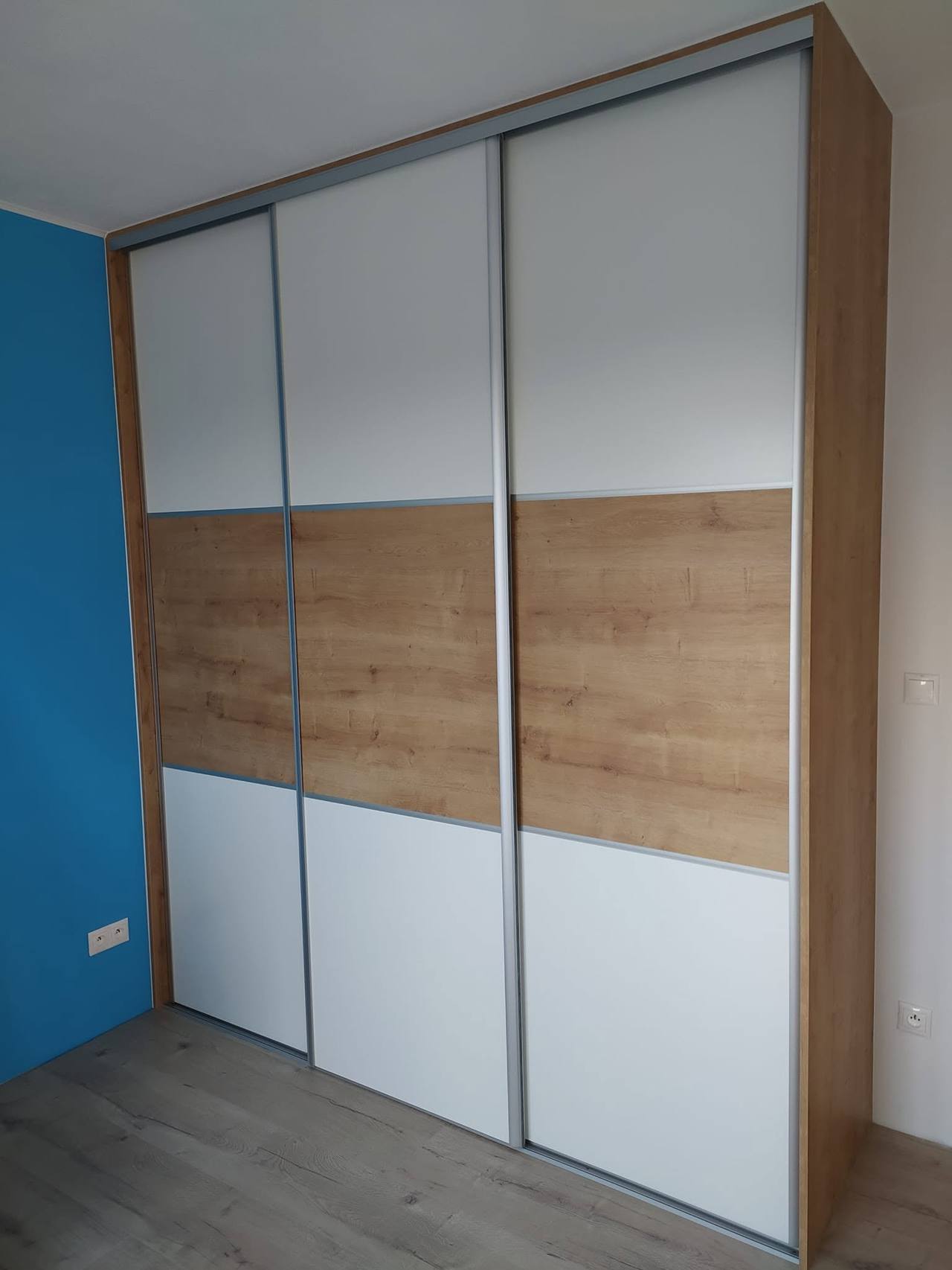 Geschlossener Kasten mit weißen und eichenfarbenen Füllungen an blauer Wand