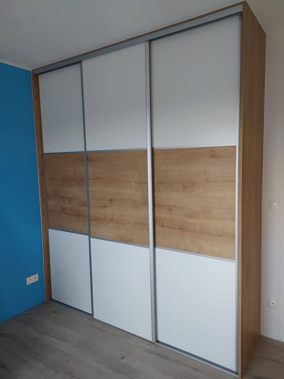 Geschlossener Kasten mit weißen und eichenfarbenen Füllungen an blauer Wand