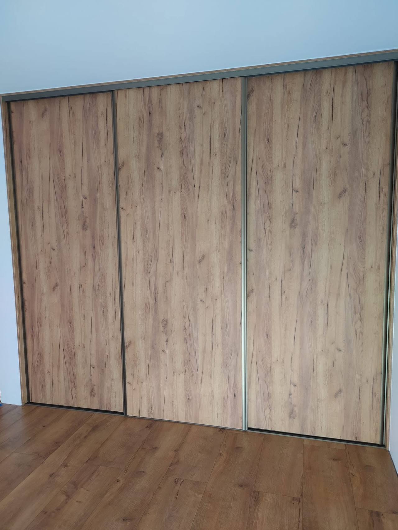 Schiebekasten in hellem Eichendekor entlang der Wand bis zum Fenster
