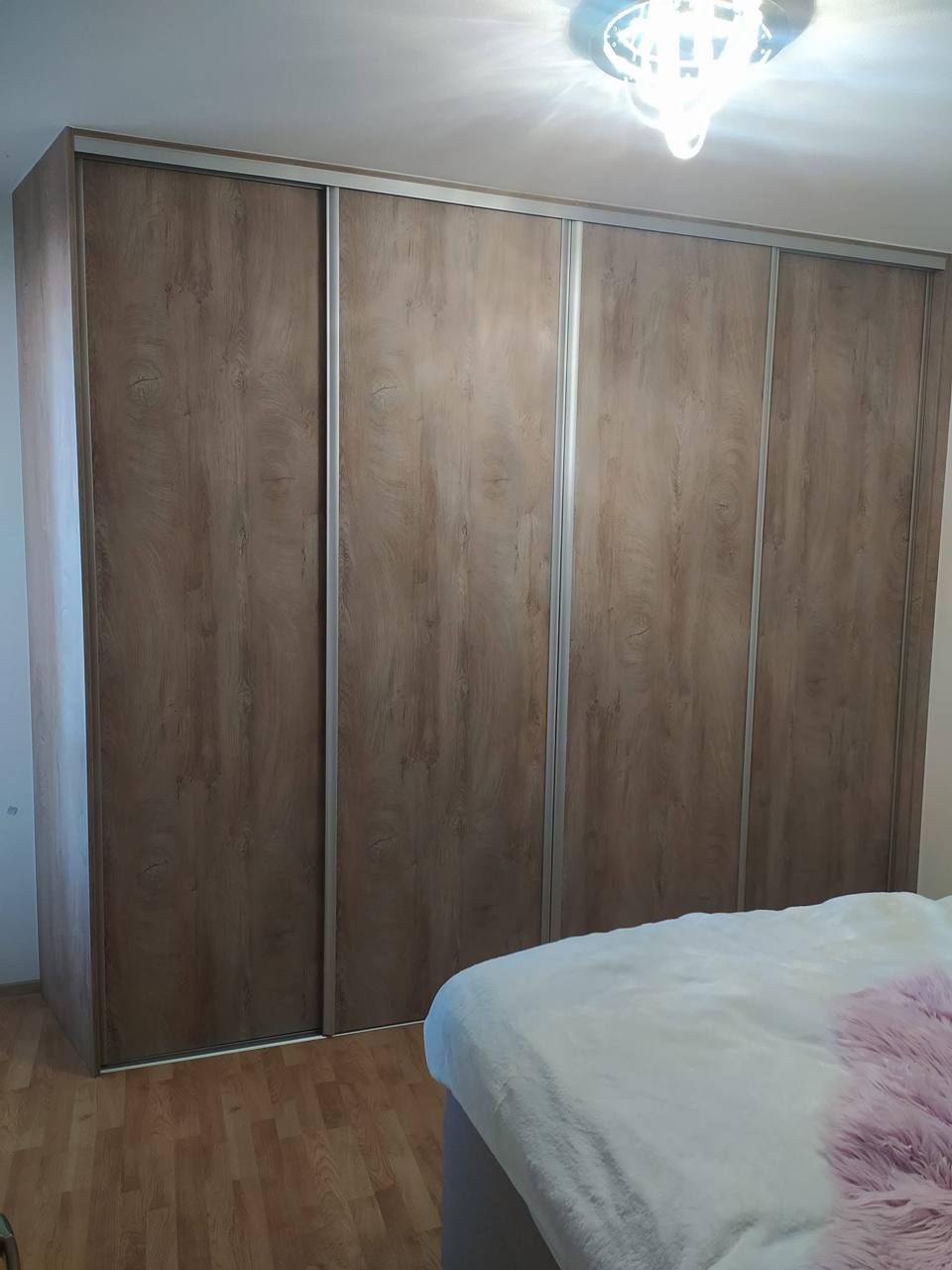Deckenhoher Schiebekasten in Eichendekor im Schlafzimmer