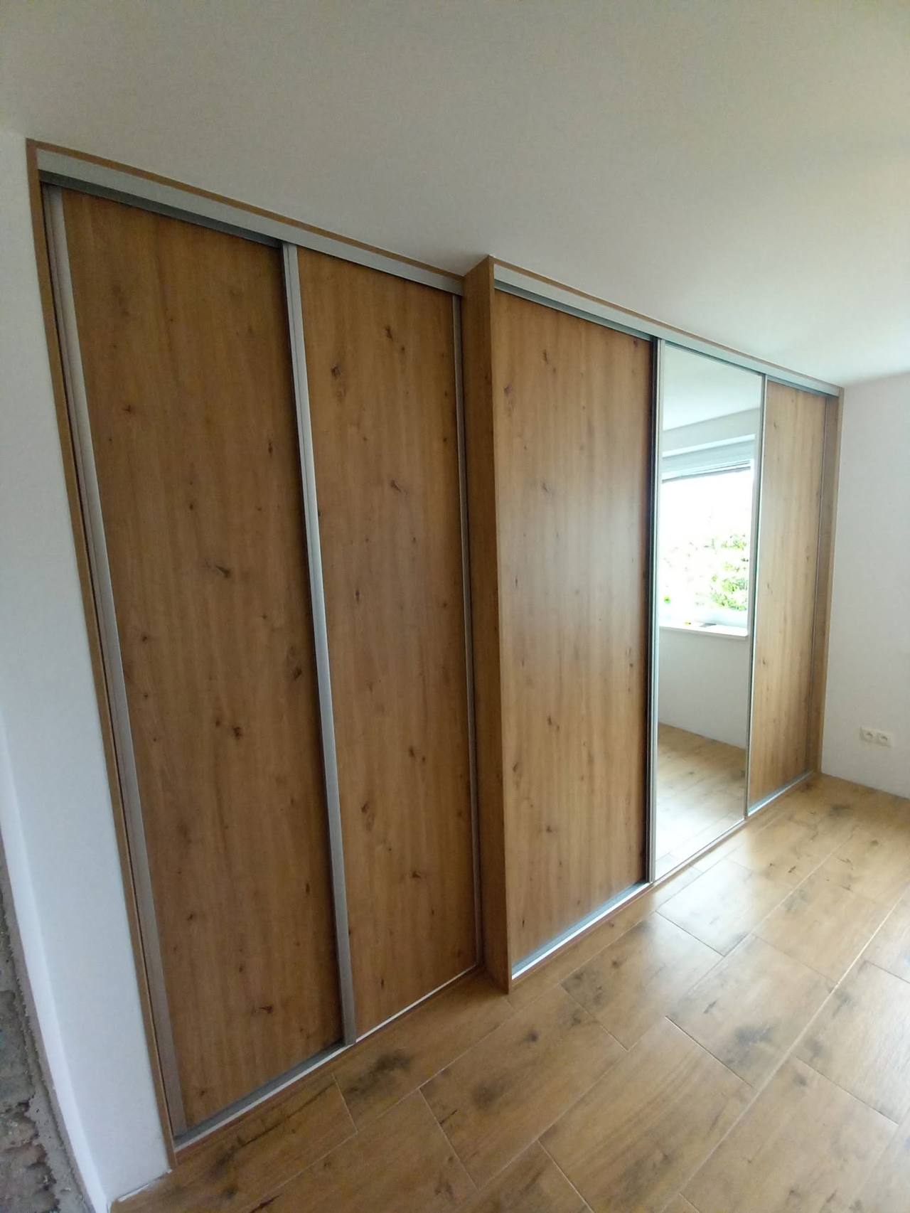 Schiebetüren in Eichendekor mit Spiegelelement beim Fenster
