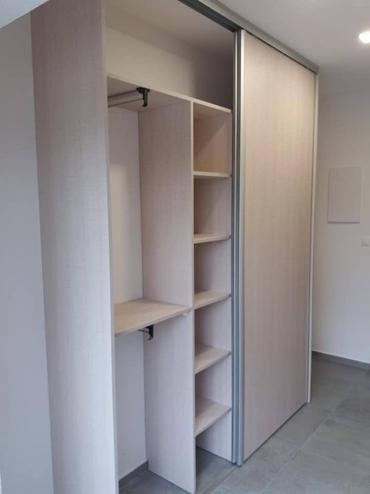 Geöffneter Kasten in Eiche-Dekor mit Kleiderstange.