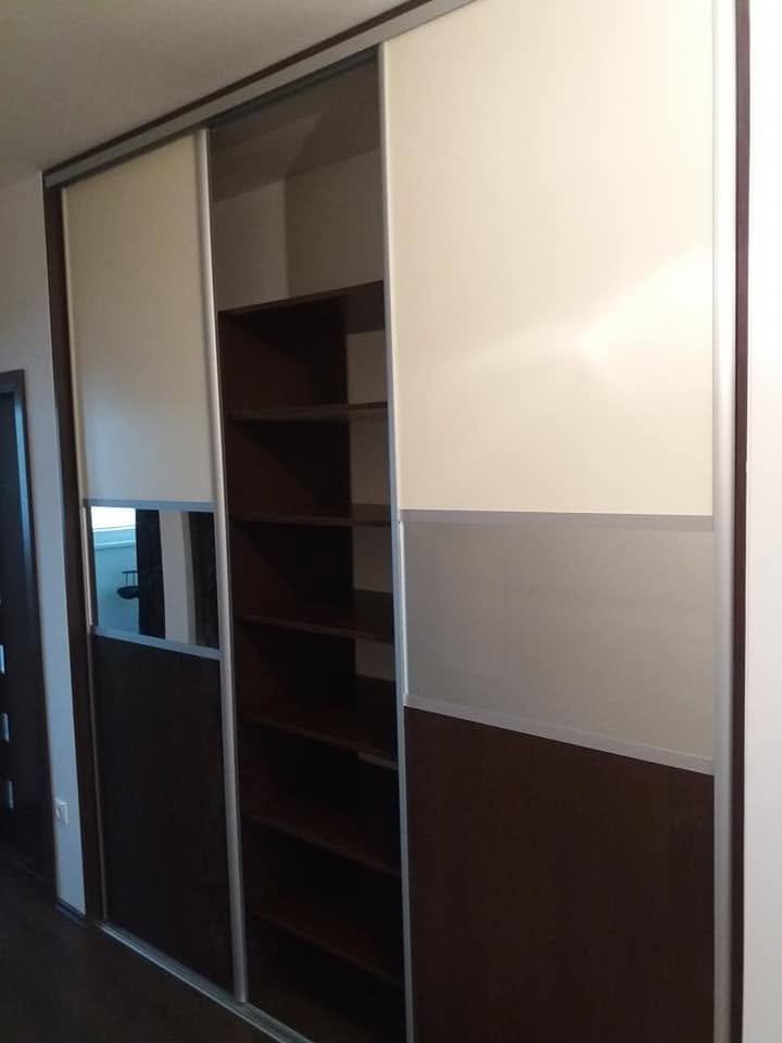 Schiebetürkasten mit cremefarbenen und Wenge-Einsätzen sowie offenem Regal daneben.