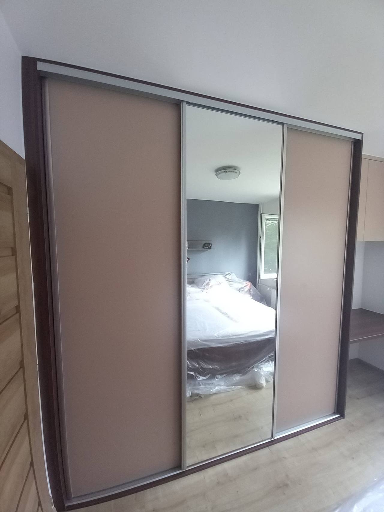 Posuvná skriňa v kapučínovej farbe so zrkadlom v spálni