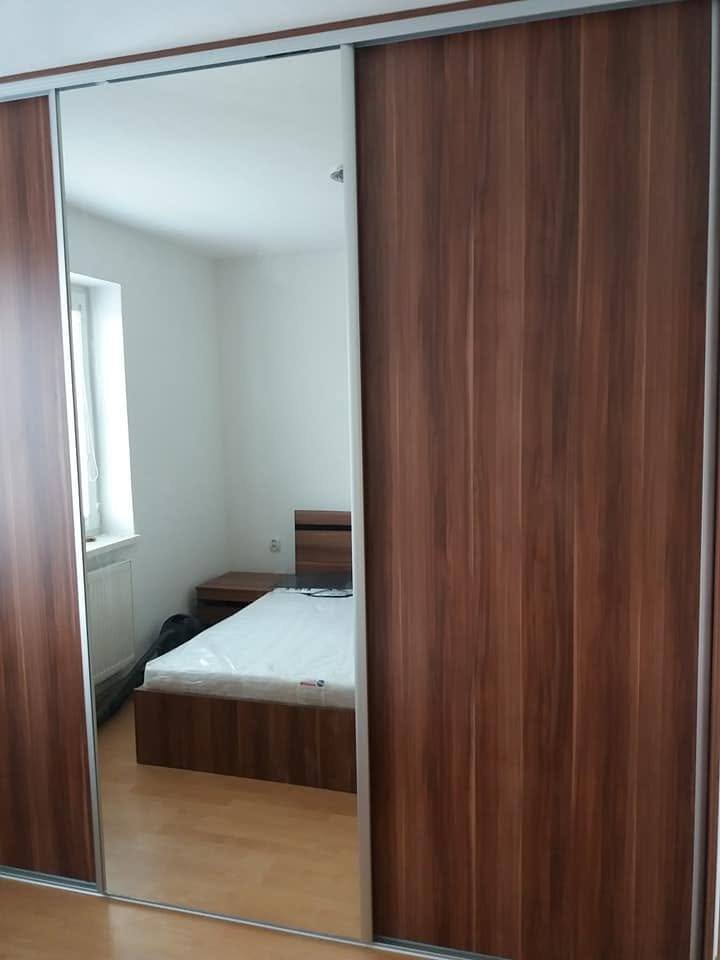 Nussbaum-Schwebetürenkasten mit Spiegel, der das Bett zeigt