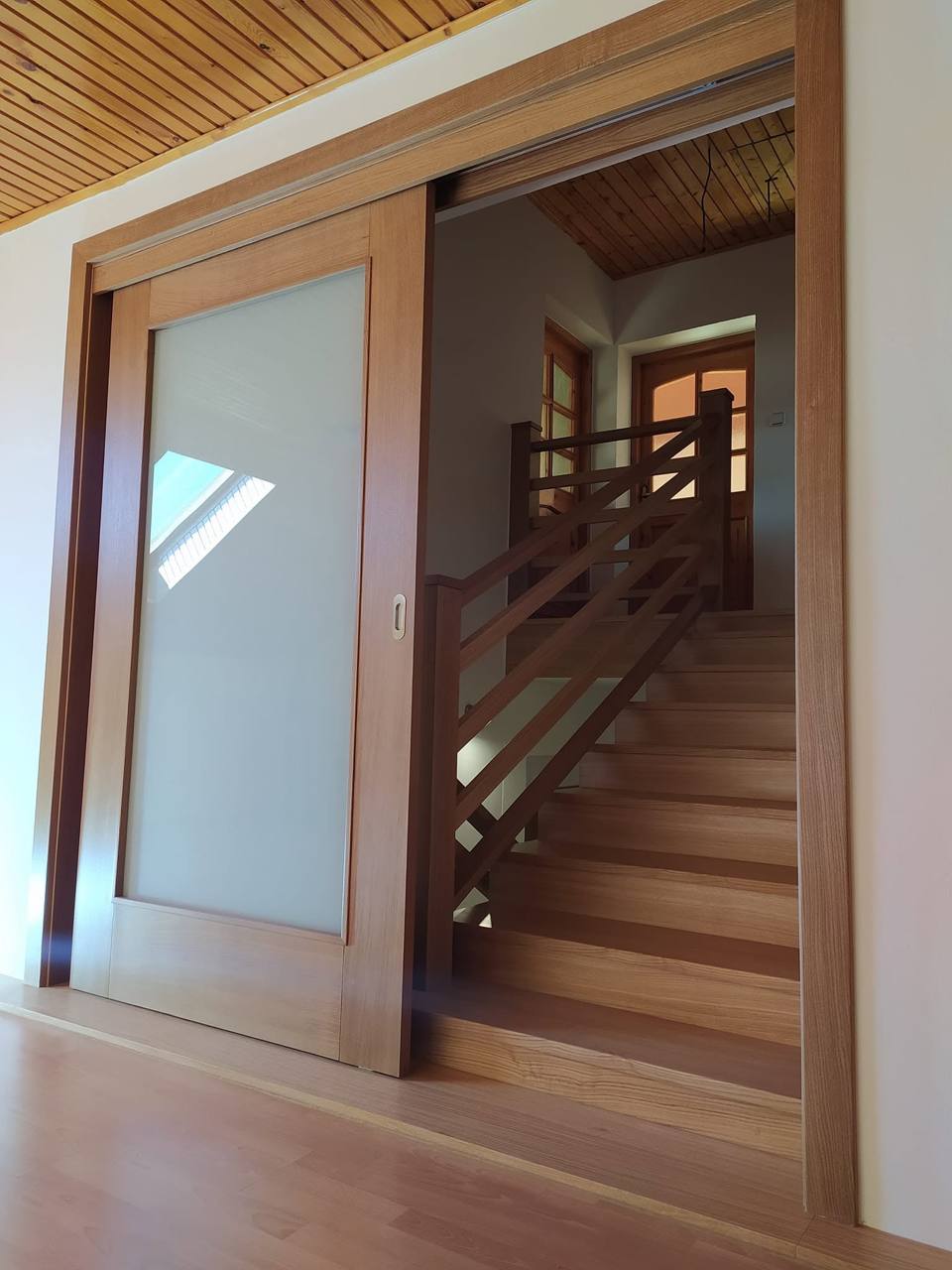 Eichen-Schiebetür mit großem Glas bei der Stiege mit Dachfenster