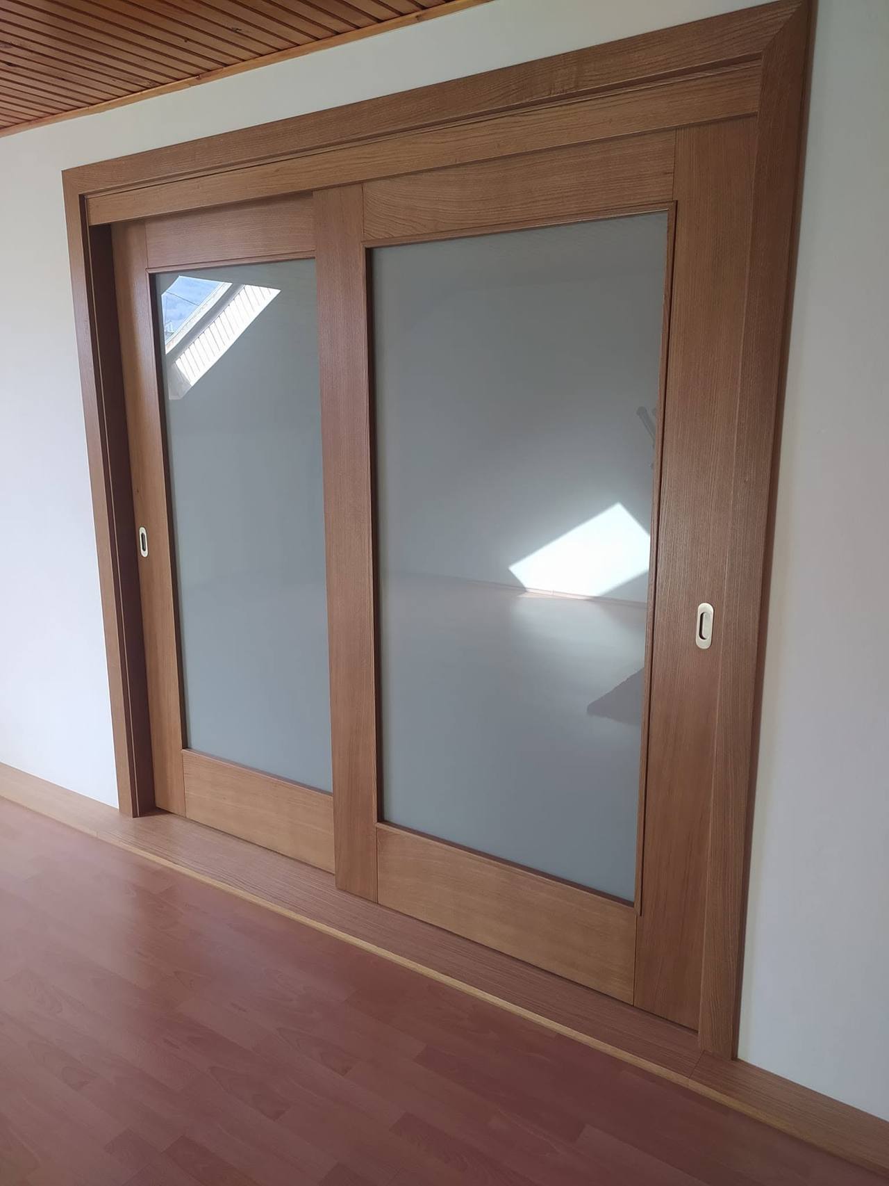 Geschlossene Eichentür mit großem Milchglas bei hellem Boden