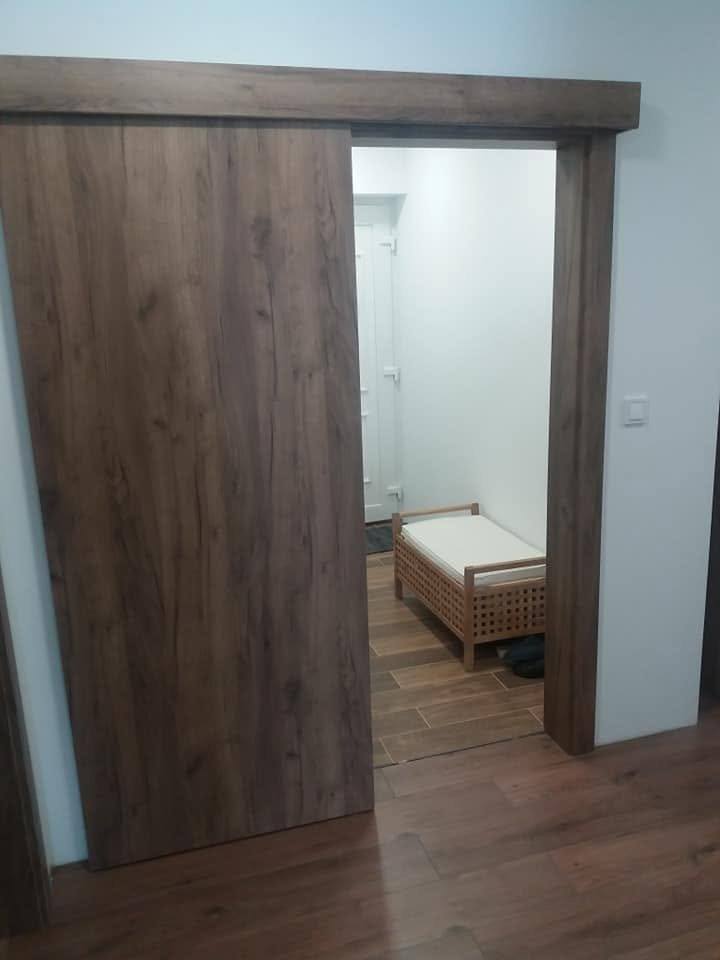 Geöffnete Schiebetür mit Zugang zum Schlafzimmer mit Bett