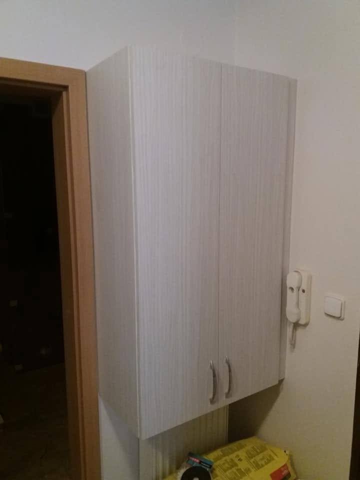 Oberer Vorzimmerschrank im weißen Holzdekor bei der Tür