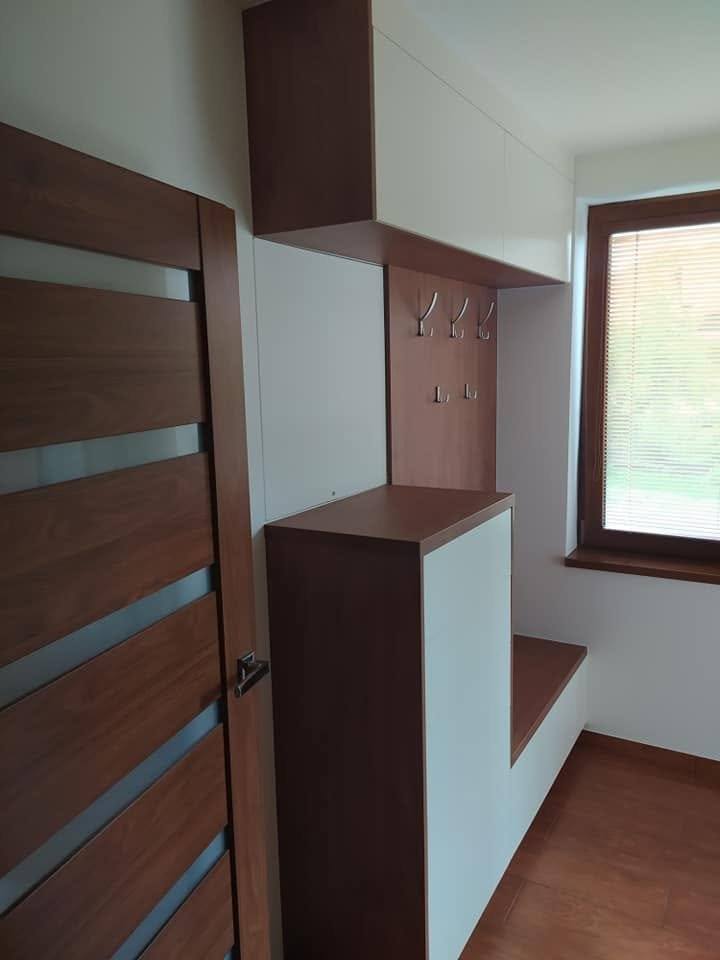 Stupňovitá biela komoda s lavicou vedľa interiérových dverí