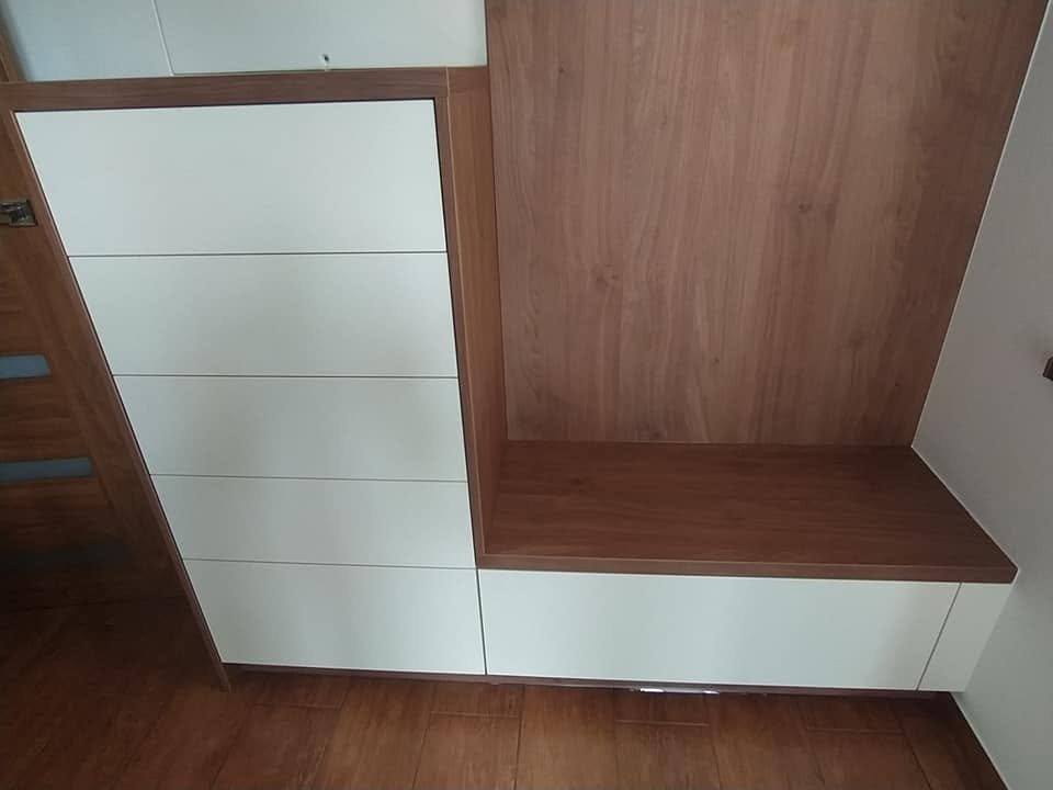 Detail bielych zásuviek bez úchytiek a orechovej lavice