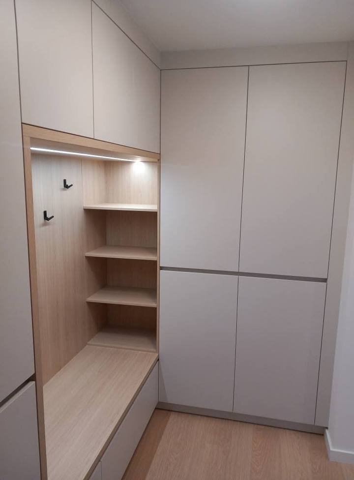 Hellgraue Kästen bis zur Decke mit beleuchteter Eichennische und Fächern