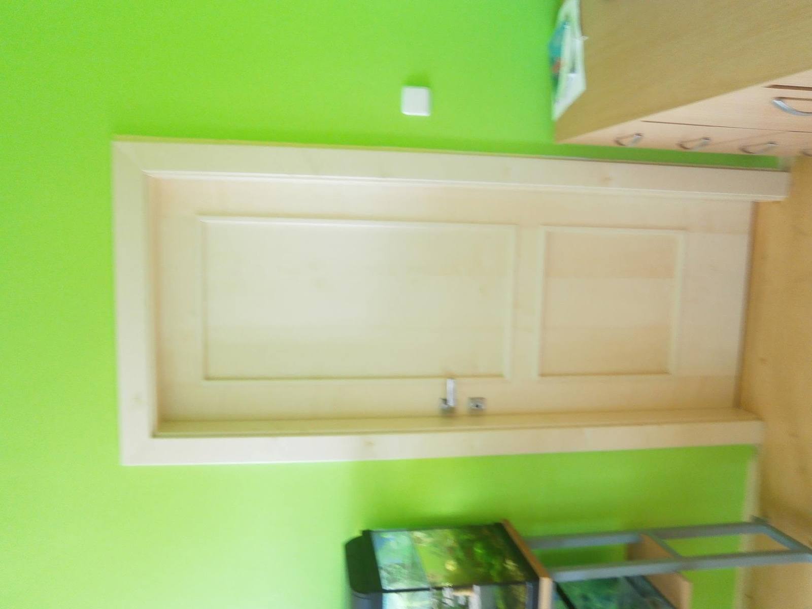 Geschlossene Deckenluke in hellem Holz unter grüner Decke